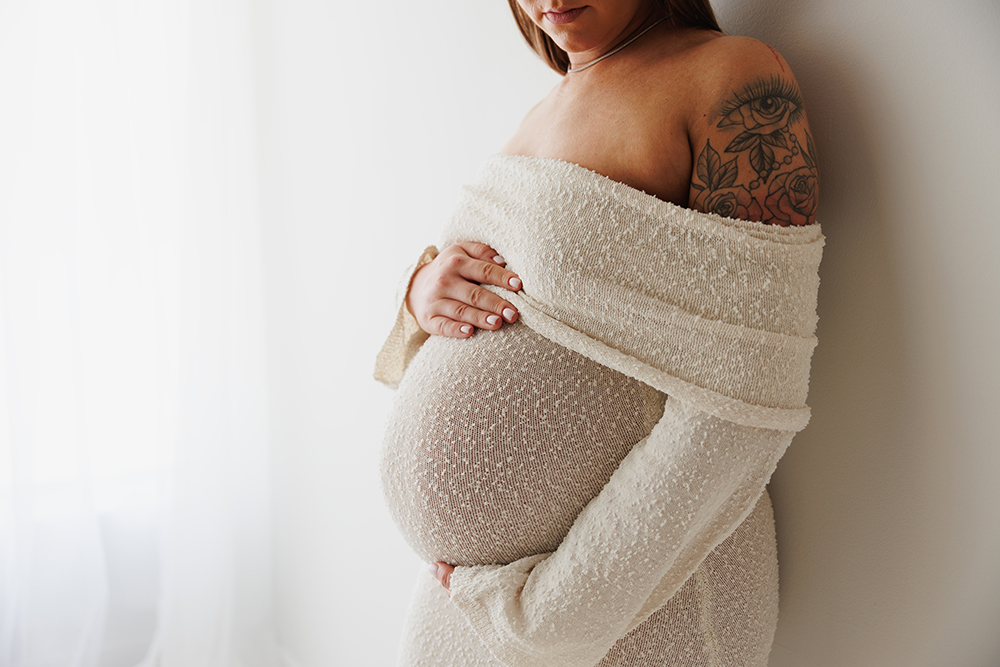 Christine Retzer, St. Charles, IL newborn photographer, photo of Mom to be holding her pregnant belly in white